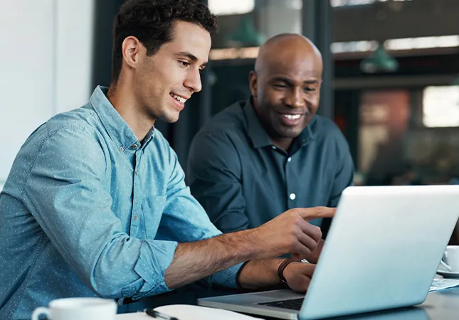 Two men looking at a laptop together.