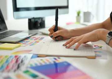 A person working with a graphics tablet next to colour swatches.