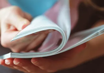 A person looking through a magazine.