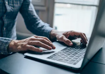 A person typing on a laptop.